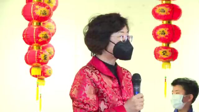 A woman wearing a red jacket and black mask.